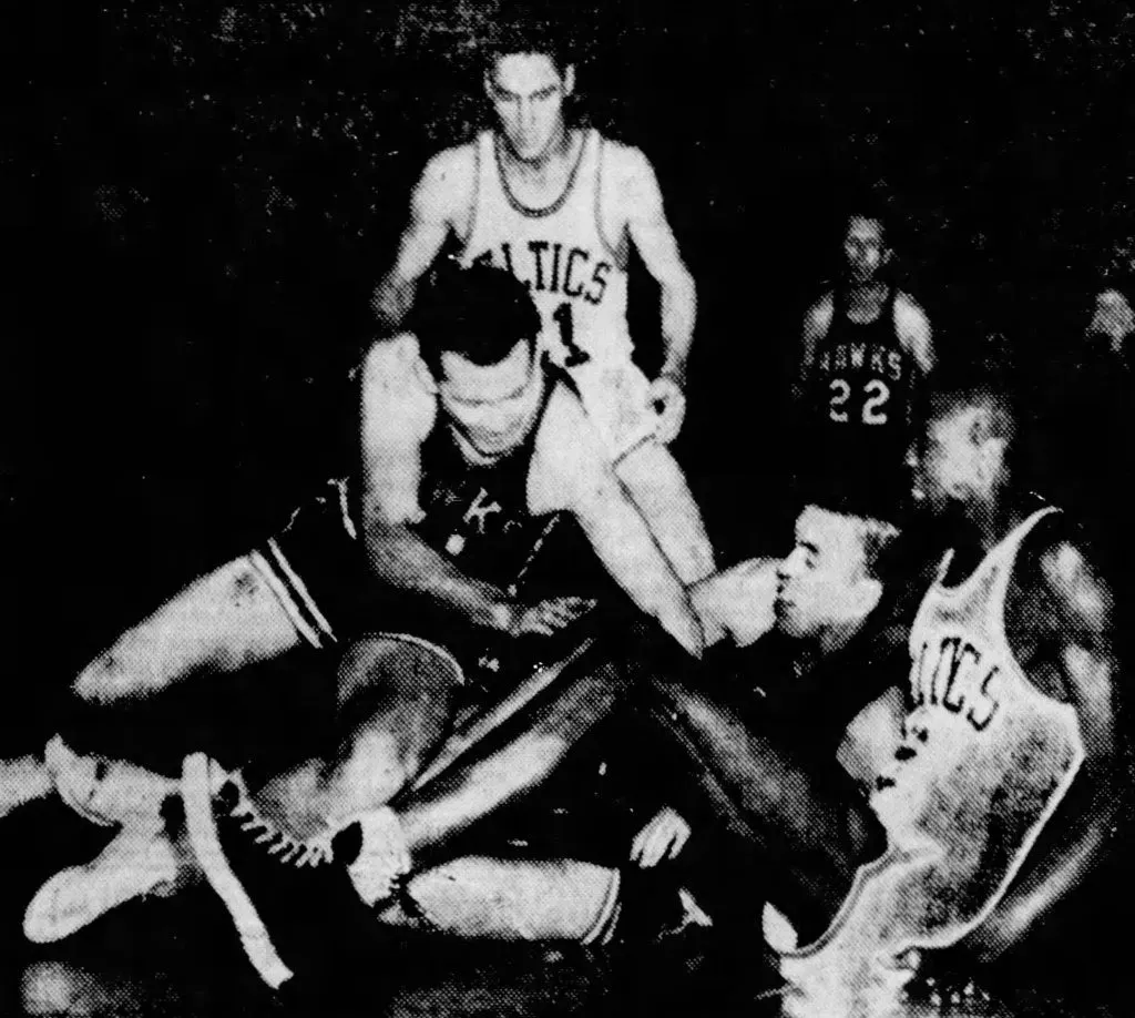 Bill Russell en position inconfortable écrasé par Jack McMahon et Chuck Share sous le regard du héros du jour, Bill Sharman. source : The Charlotte Observer