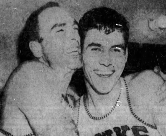 Alex Hannum (à gauche) en tenue car toujours joueur même s’il ne participe quasiment plus au match. Il félicite avec bonheur son Rookie décisif dans ce match 6.